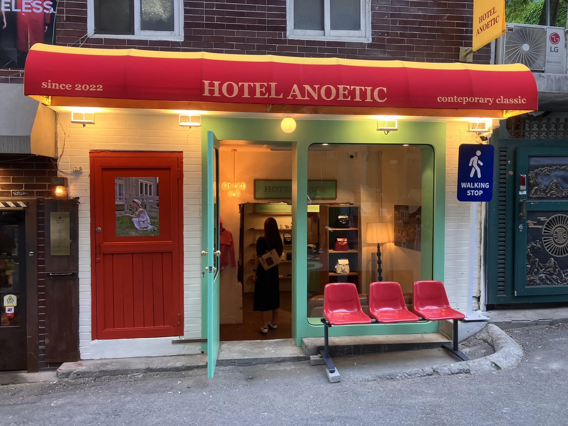 호텔 아노에틱 정면 외관, HOTEL ANOETIC 차양과 빨간 플라스틱 벤치